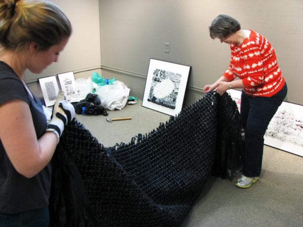 Artist Sabyna Sterrett and Solo Artist Coordinator Megan Fox install half of the behemoth "Environmental Pleading/Dead Conversation."