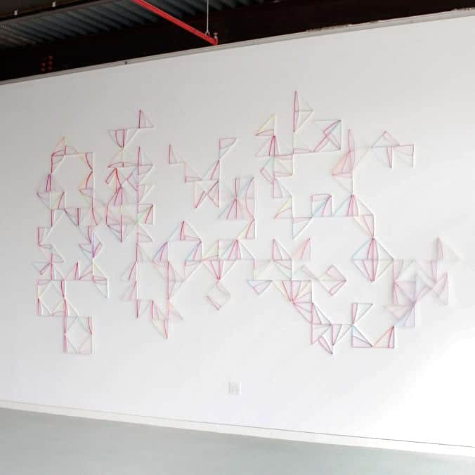 Modular Wall Installation: Right Triangle (Magenta) by Alex Paik, installed at ODETTA (2015). Gouache, colored pencil, paper, nails. Dimensions variable.