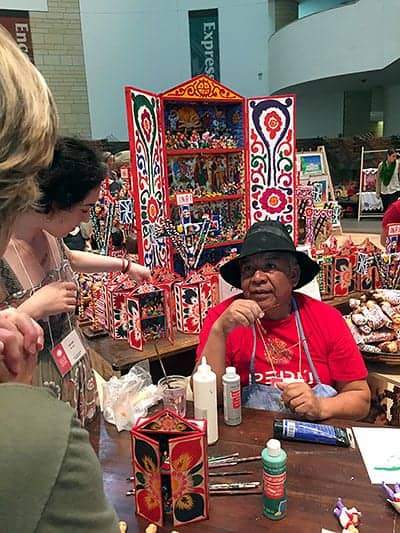 Retablo artist Alfredo Lopez Morales demonstrated how he paints the small clay figures that go in these portable altars.