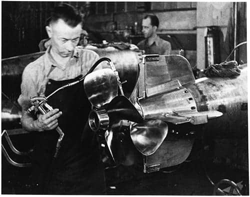 A worker at the Naval Torpedo Station lubricates a torpedo propeller during World War II. (Photo from the collection of George L. Dant, copyright the Naval History and Heritage Command.)